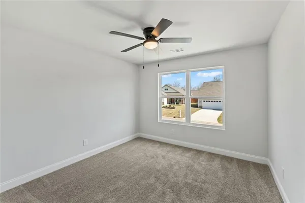 an empty room with a window and a ceiling fan