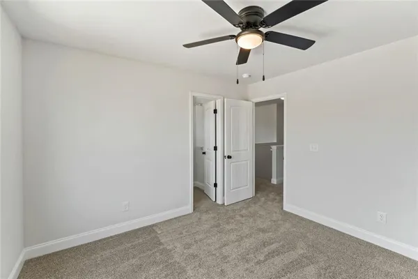 an empty room with a ceiling fan and a fan