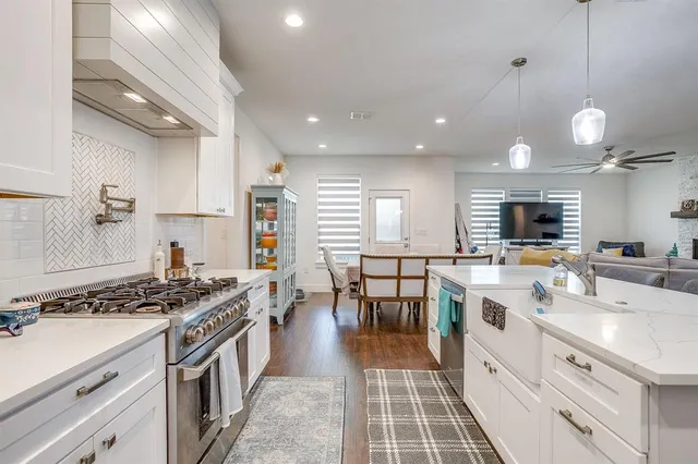 a view of a kitchen with kitchen island a chandelier wooden floor and a dining table