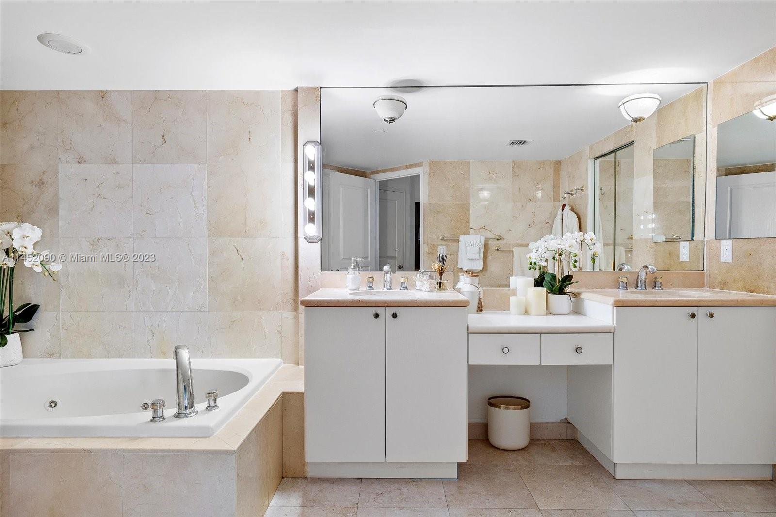 8925 Collins Avenue, Unit 9J Surfside, FL 33154 - Photo 20 of 41 a bathroom with a double vanity sink mirror and bathtub