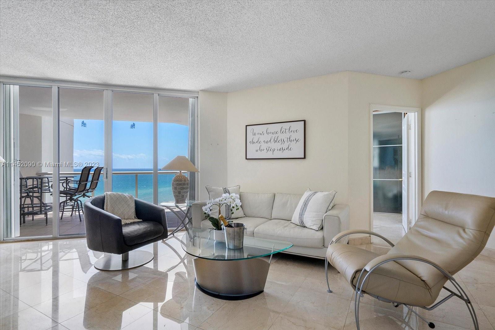 8925 Collins Avenue, Unit 9J Surfside, FL 33154 - Photo 2 of 41 a living room with furniture and a potted plant
