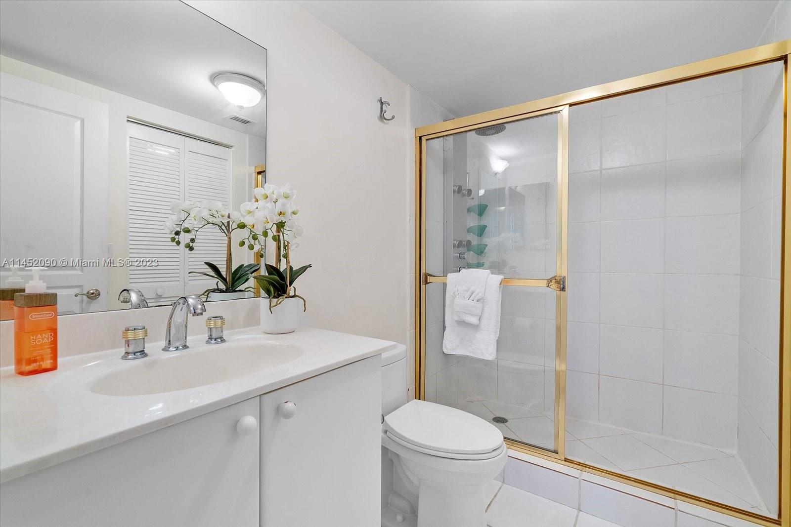 8925 Collins Avenue, Unit 9J Surfside, FL 33154 - Photo 25 of 41 a bathroom with a shower sink vanity mirror and toilet
