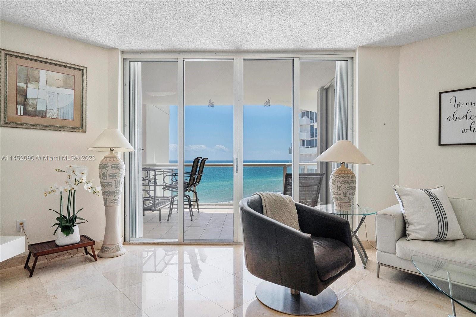 8925 Collins Avenue, Unit 9J Surfside, FL 33154 - Photo 4 of 41 a living room with furniture and a floor to ceiling window