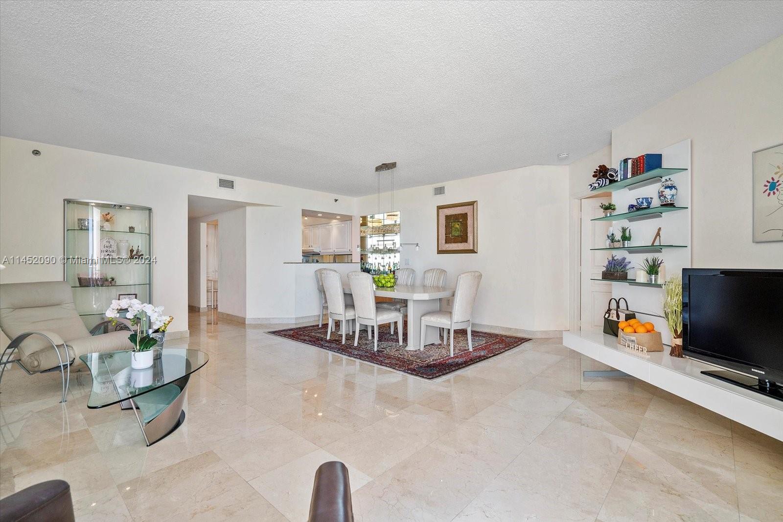 8925 Collins Avenue, Unit 9J Surfside, FL 33154 - Photo 9 of 41 a view of a livingroom with furniture and a flat screen tv