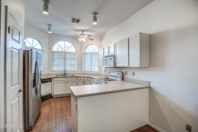 a view of a kitchen sink and wooden floor