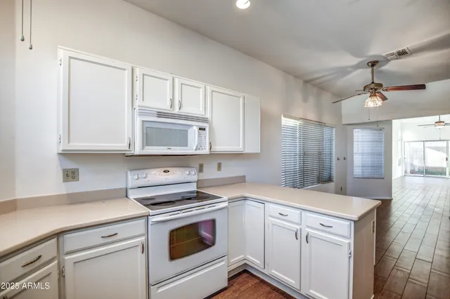 a kitchen with white cabinets and white appliances
