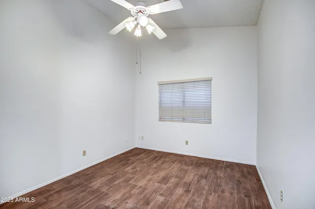 an empty room with a window and a fan
