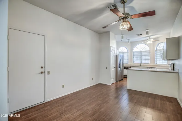 a view of a kitchen with a wooden floor and a ceiling fan