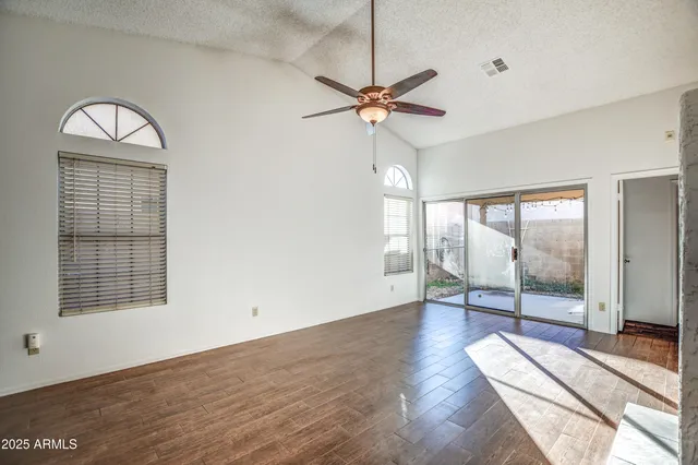 a view of a livingroom with wooden floor and a ceiling fan