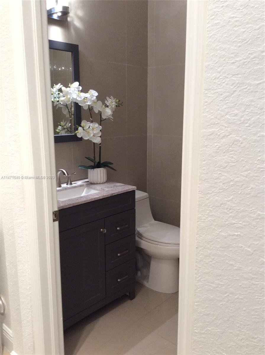 a bathroom with a sink vanity and toilet