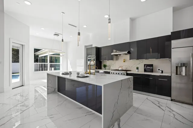 a kitchen with stainless steel appliances granite countertop a sink counter space cabinets and a large window