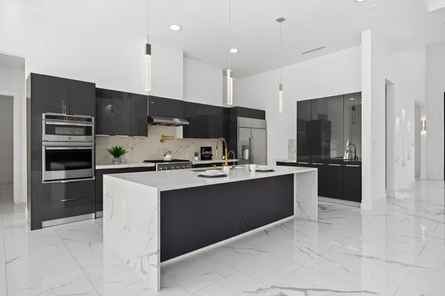a large kitchen with stainless steel appliances and a sink