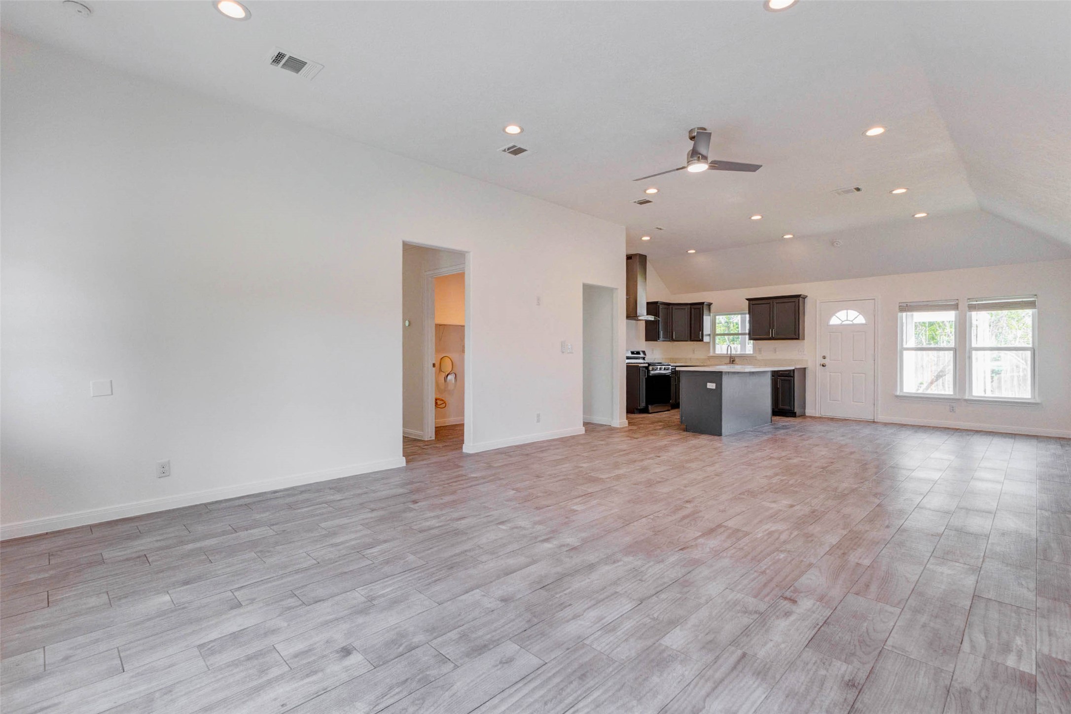 9811 Kerr Street Houston, TX 77029 - Photo 4 of 22 Expansive open-concept design connecting the living area directly to the kitchen, perfect for modern living and entertaining. The wide layout offers flexibility for furniture placement, while the high ceilings create an even greater sense of space. This inviting area is ideal for hosting gatherings or enjoying everyday comfort.