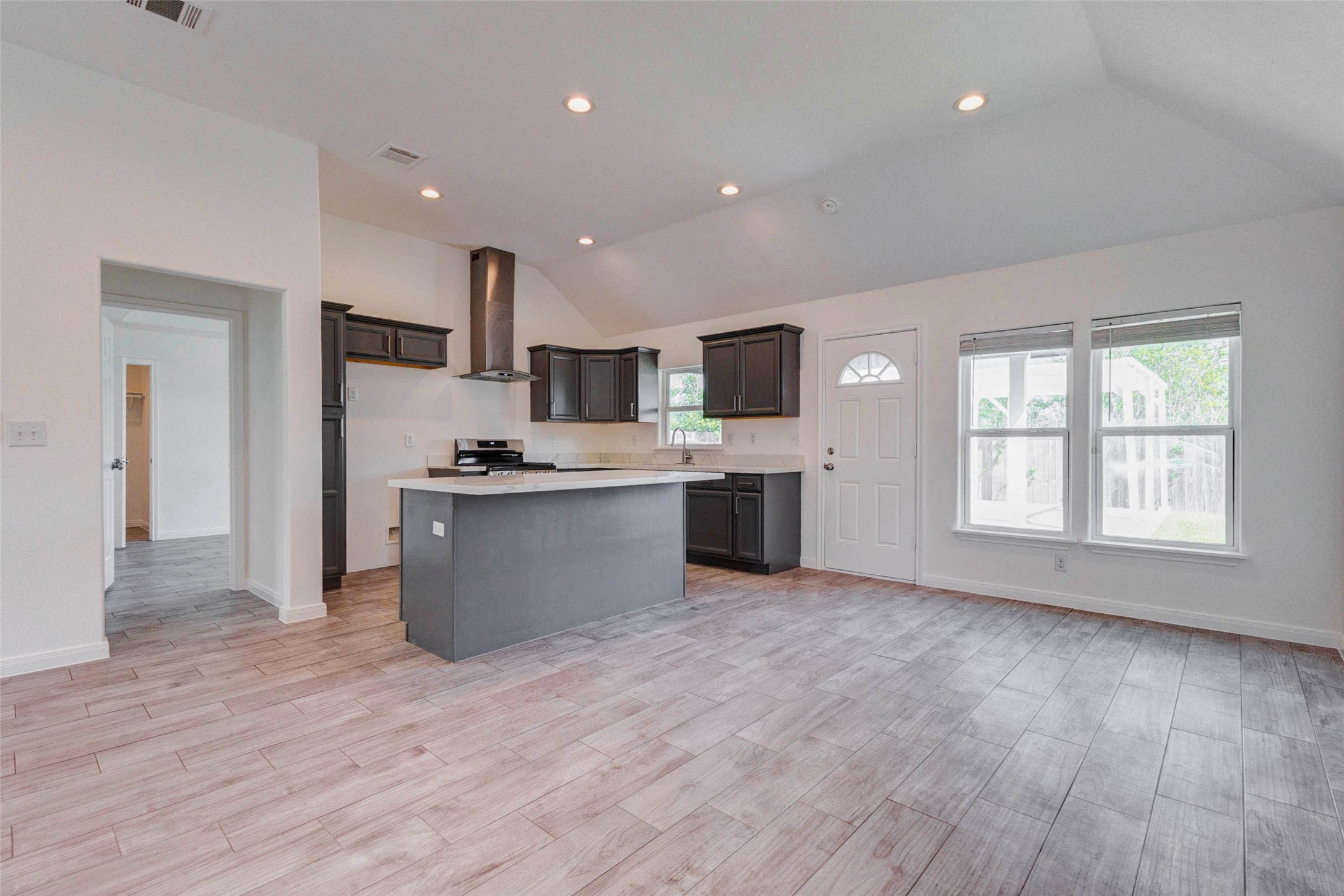 9811 Kerr Street Houston, TX 77029 - Photo 5 of 22 Beautifully integrated kitchen and living area showcasing a large island, modern finishes, and abundant natural light. The layout is designed for functionality and flow, allowing easy interaction between spaces. Whether cooking, relaxing, or entertaining, this central living area serves as the heart of the home with style and convenience.