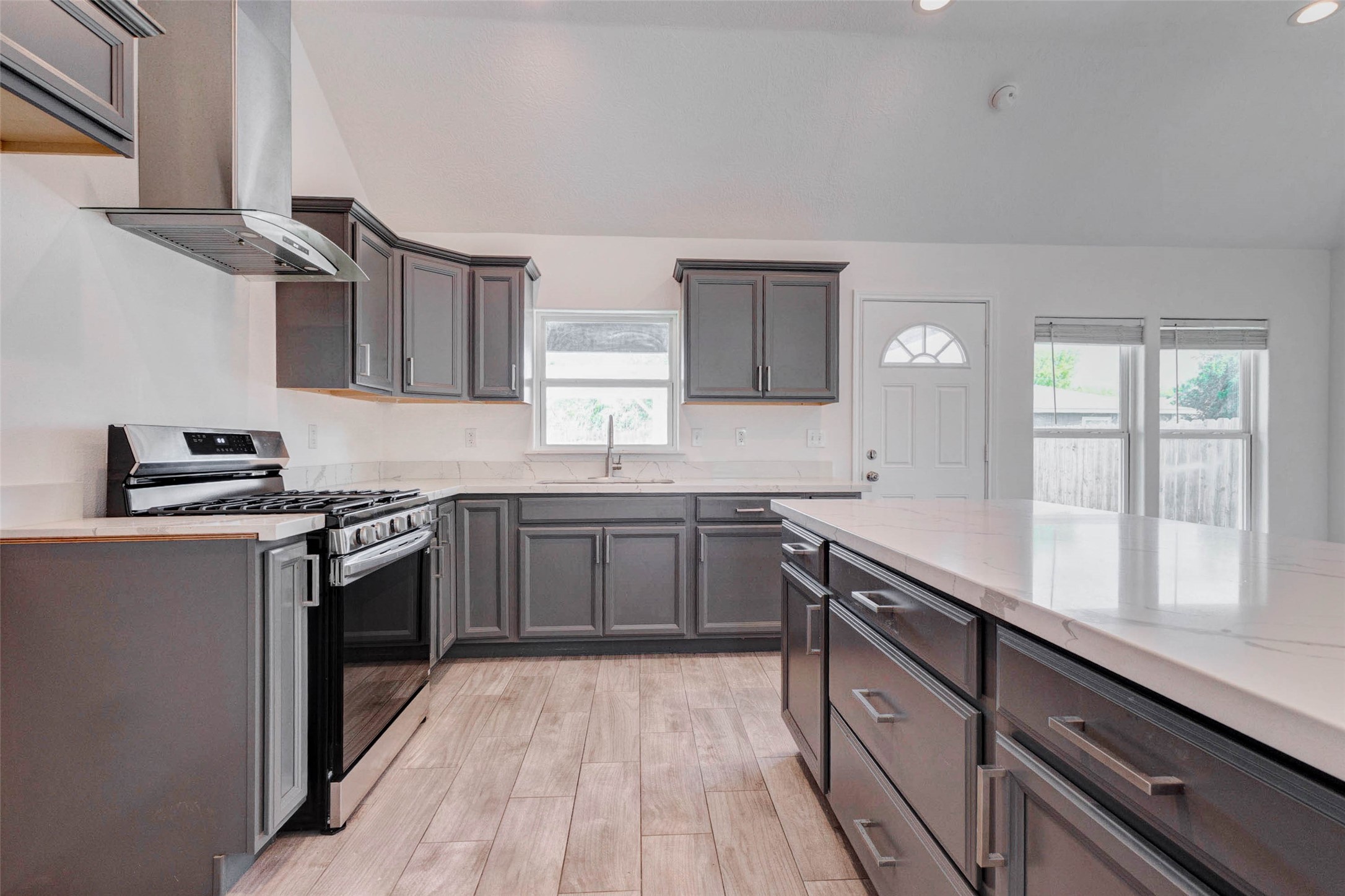 9811 Kerr Street Houston, TX 77029 - Photo 9 of 22 Another view of the thoughtfully designed kitchen highlighting the generous counter space and functional layout. The large island provides additional prep space and seating options, while the surrounding cabinetry offers plenty of storage. Clean lines, modern finishes, and natural light combine to create a bright and efficient space perfect for both casual meals and hosting guests.