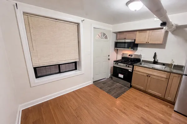 a kitchen with stainless steel appliances granite countertop a stove a sink and a microwave