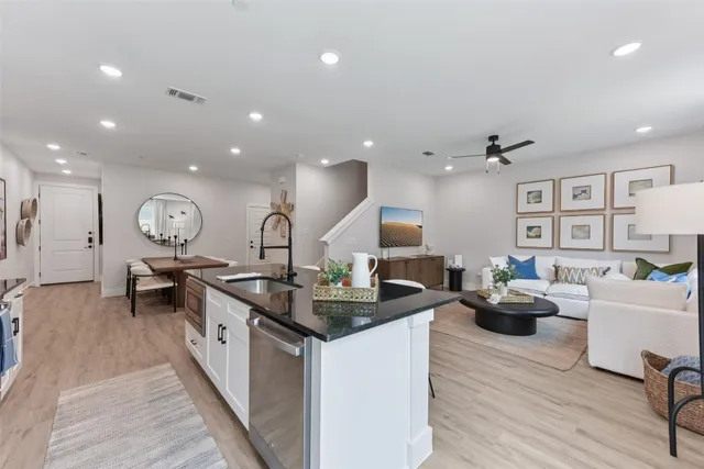 a view of a patio with couches chairs potted plants and wooden floor