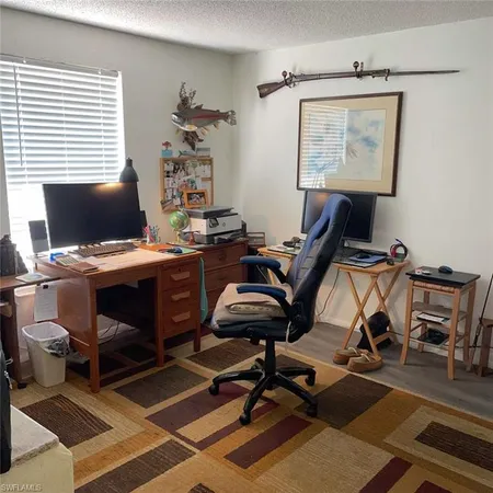 a view of a workspace with furniture and a window