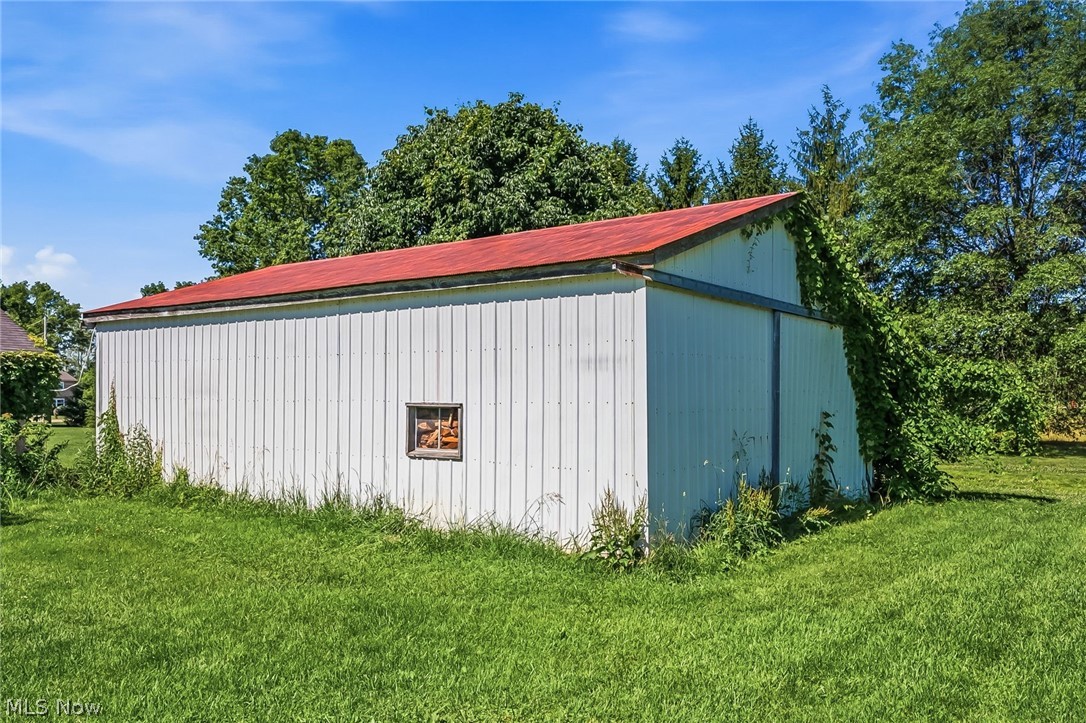 6890 Refugee Road Pickerington, OH 43147 - Photo 40 of 49 Detached outbuilding with white corrugated siding, a red sloped roof, and a small framed window