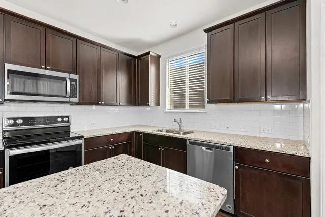 a view of a kitchen with a sink and a refrigerator