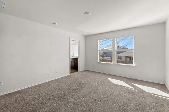 an empty room with a window and a mirror