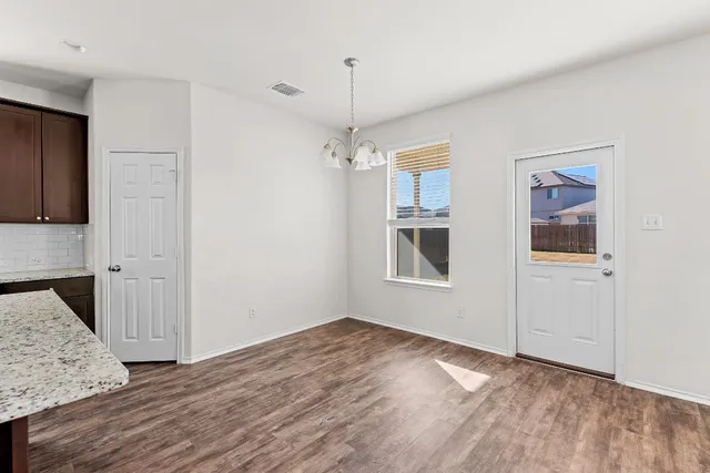 a kitchen with stainless steel appliances granite countertop a stove a sink dishwasher a refrigerator and a oven with wooden floor