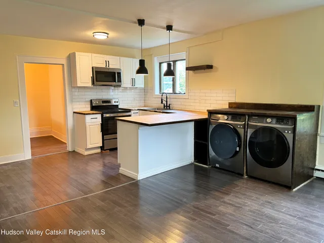 a kitchen with stainless steel appliances a stove a sink and a microwave