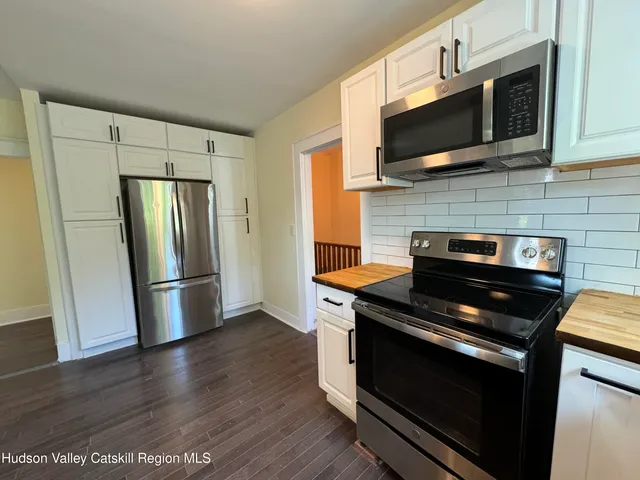 a kitchen with stainless steel appliances a sink a stove top oven a counter space and cabinets