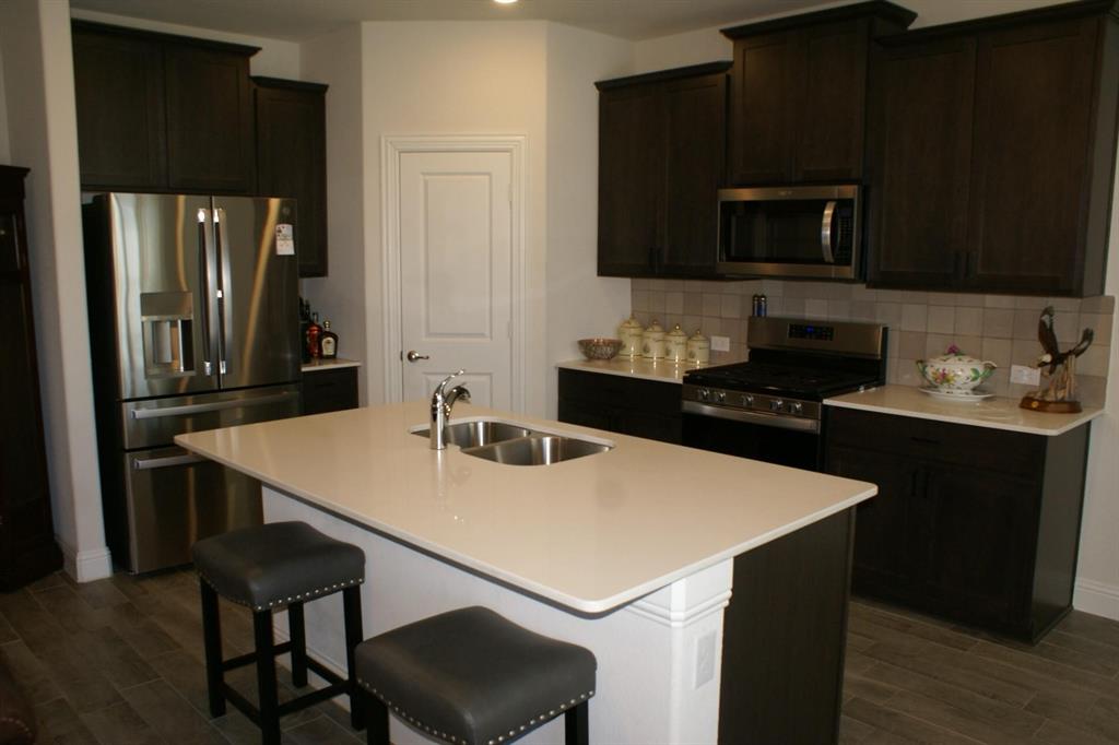 11132 Ranchera Drive Aubrey, TX 76227 - Photo 2 of 30 a kitchen with a stove a sink and a refrigerator