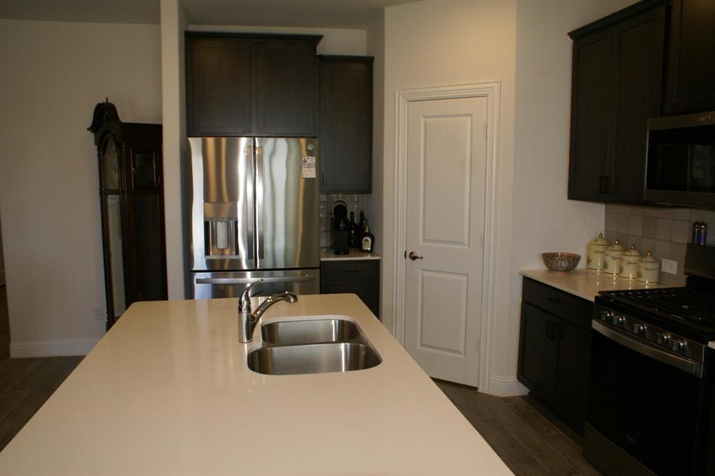 11132 Ranchera Drive Aubrey, TX 76227 - Photo 3 of 30 a kitchen with a sink and a stove top oven