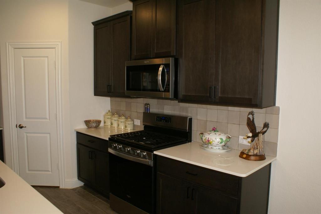 11132 Ranchera Drive Aubrey, TX 76227 - Photo 4 of 30 a kitchen with a sink stove and microwave
