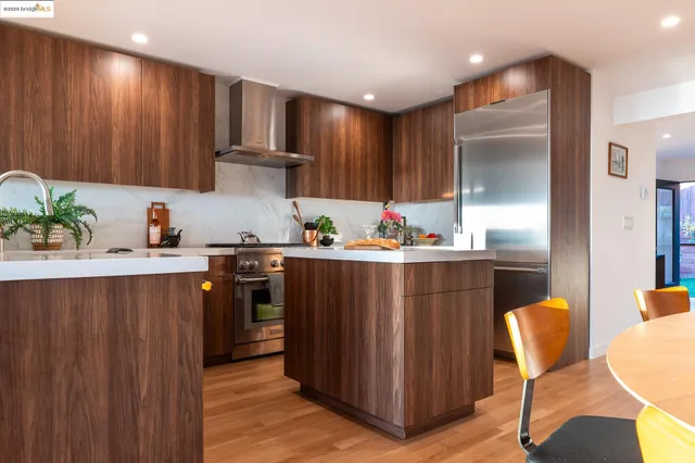 a kitchen with stainless steel appliances granite countertop a refrigerator and a stove top oven