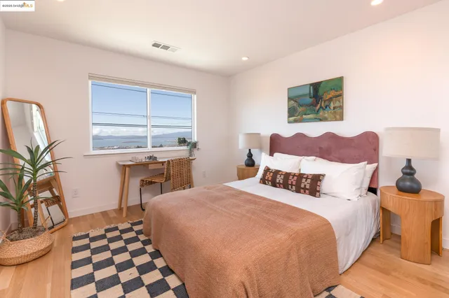 a bedroom with a bed and a potted plant