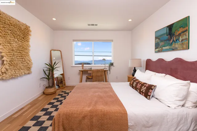 a bedroom with a bed and a painting on the wall