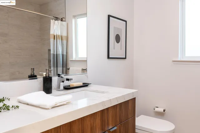 a bathroom with a sink vanity granite and toilet