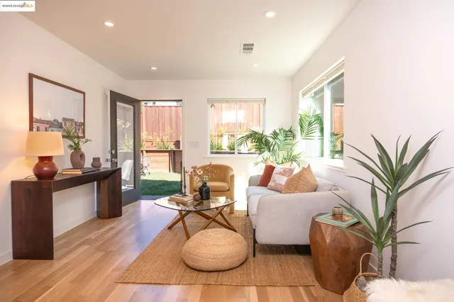 a living room with furniture potted plant and a large window