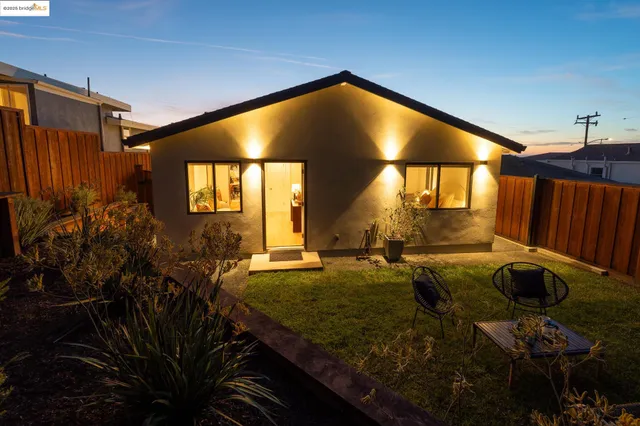 a view of a house with backyard and sitting area