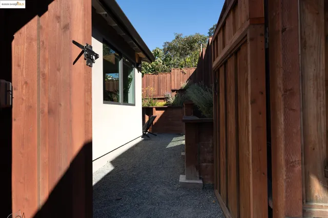 a view of a house with backyard and wooden fence