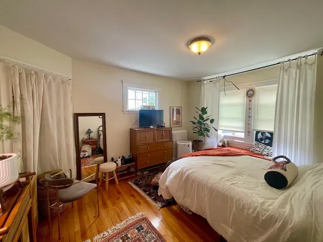 a bedroom with a bed and large windows