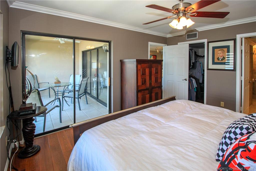 4720 Northeast Sandpebble Trace, Unit 403 Stuart, FL 34996 - Photo 17 of 40 a bedroom with a bed and a chandelier