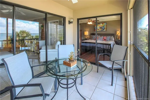 a dining room with furniture and large windows