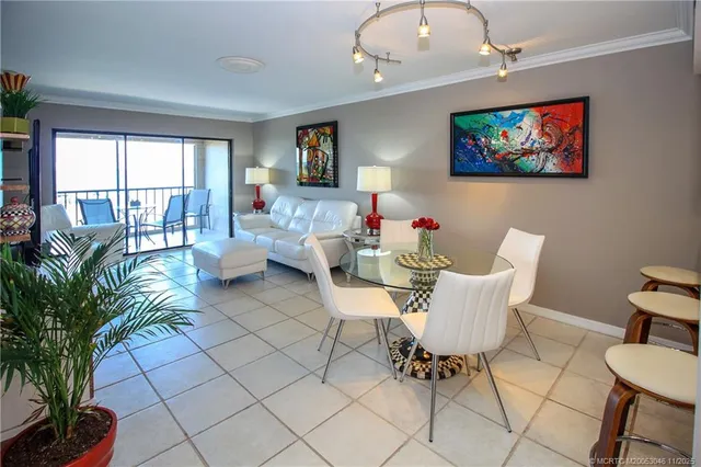 a dining room with furniture a painting and a potted plant