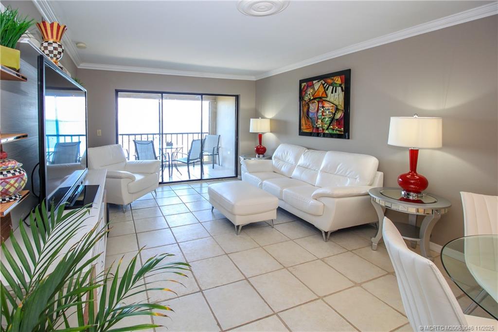 4720 Northeast Sandpebble Trace, Unit 403 Stuart, FL 34996 - Photo 5 of 40 a living room with furniture and a floor to ceiling window