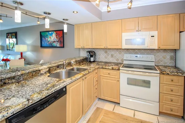 a kitchen with granite countertop a sink stove and cabinets