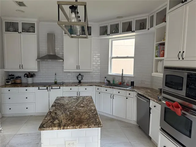 a kitchen with stainless steel appliances granite countertop a stove sink and cabinets