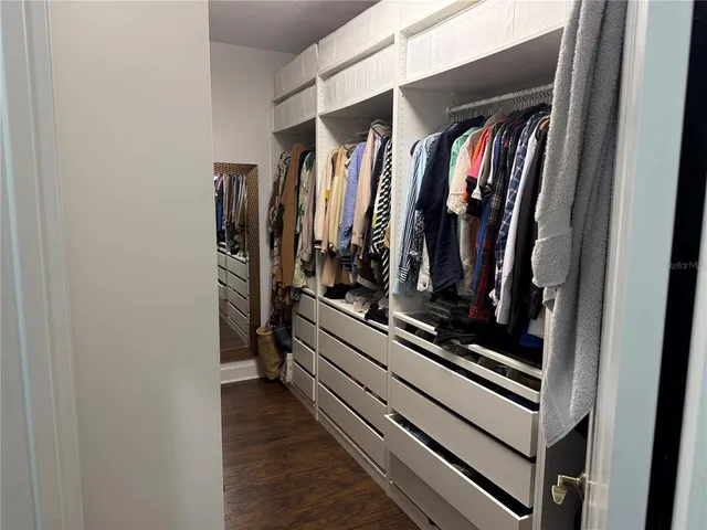 a view of walk in closet with clothes and shoes