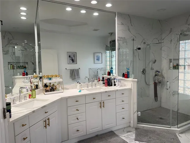 a bathroom with a bathtub shower sink mirror and toilet