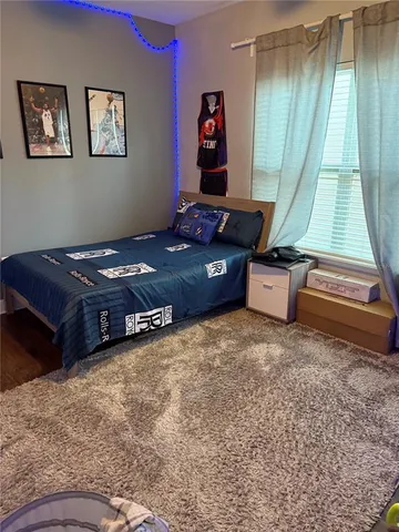 a bed sitting in a bedroom next to a lamp