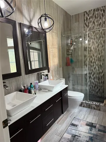 a bathroom with a sink a toilet and shower