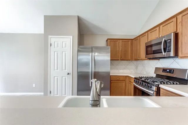 a kitchen with stainless steel appliances granite countertop a refrigerator and a stove top oven